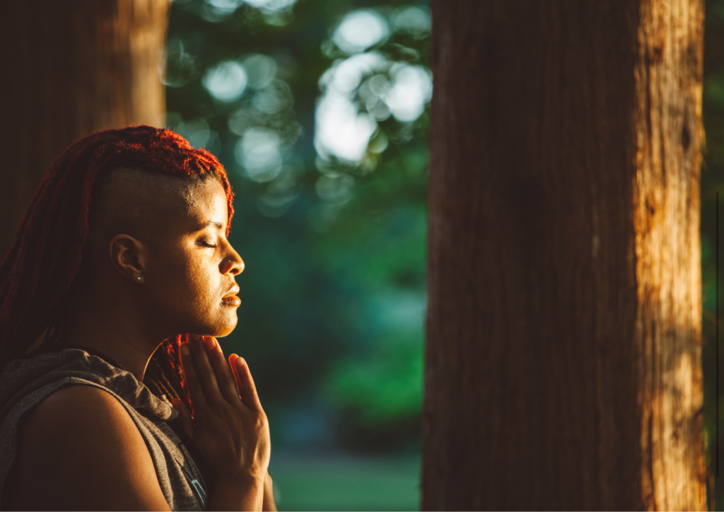 Person meditating peacefully outdoors, sitting cross-legged on the grass with eyes closed, surrounded by nature and soft sunlight, symbolizing inner calm and mindfulness amidst natural surroundings