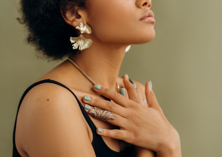 Woman standing with her hand gently placed on her chest and eyes closed, exuding a sense of calm, self-compassion, and connection to her inner self.